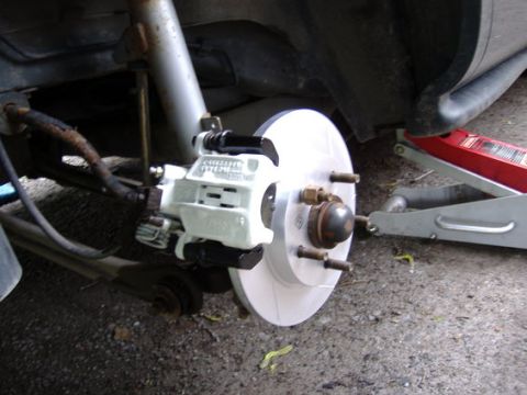 1998 Ford Taurus - Close-up of a 1998 Ford Taurus rear brake assembly, showing a newly painted caliper and rotor.