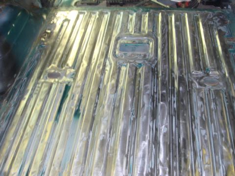 1996 Ford Bronco - The interior floor pan of a vehicle, showing ribbed metal construction and areas prepared for repair.