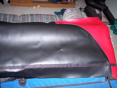 1972 Ford Ranchero - A black and red car seat cover is shown in a room with furniture and exercise equipment.