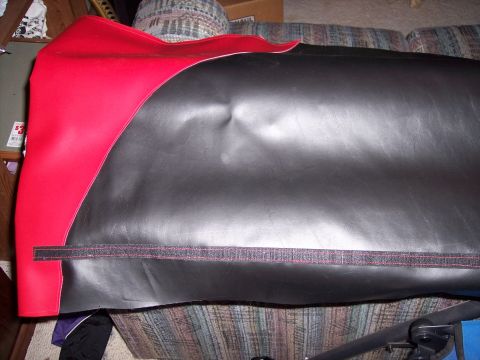 1972 Ford Ranchero - Close-up of red and black interior upholstery, possibly a seat cover or panel, with stitching and a velcro strip visible.