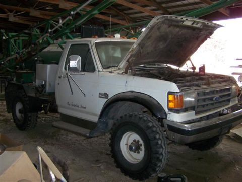 1995 Ford Bronco - This Ford F-Series truck, likely from the early 1990s, is equipped with a substantial agricultural sprayer.