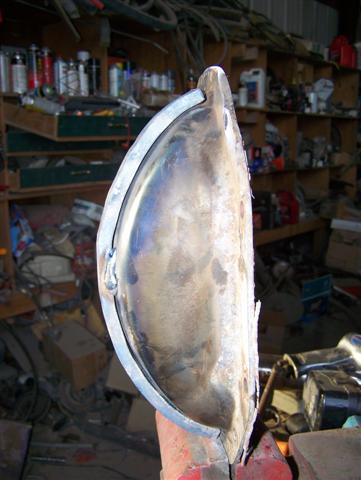 1995 Ford Bronco - A metal part, possibly a fender or body panel, is shown in a workshop setting. The registry claims it is from a 1995 Ford Bronco, but this…