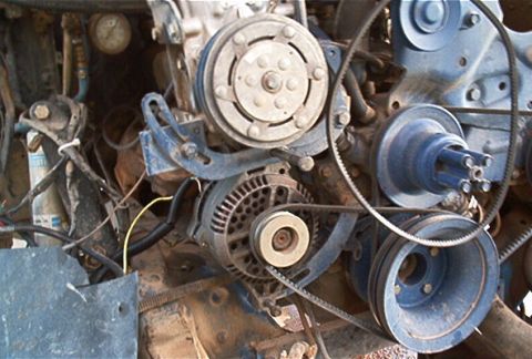 1986 Ford Bronco - Close-up view of engine components including the alternator and AC compressor.