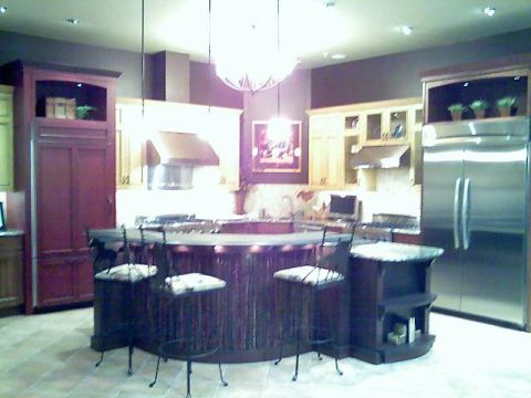 2006 Ford E350 - A modern kitchen features a large island with bar stools and a stainless steel refrigerator.