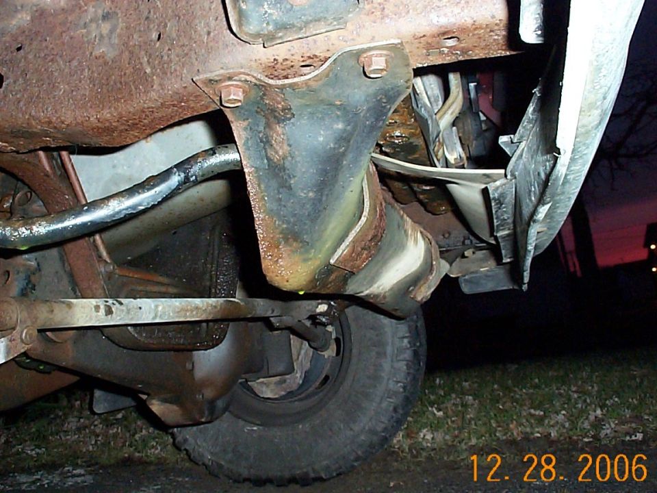 Undercarriage view of rusty truck frame and suspension components