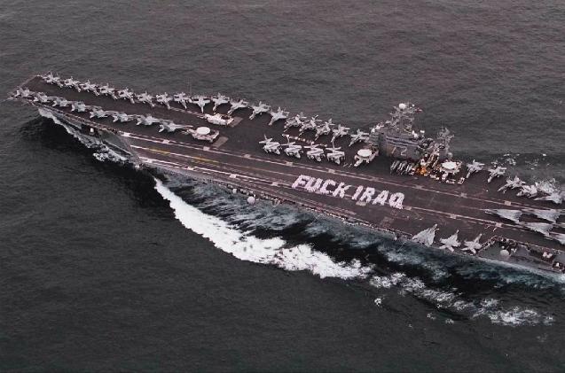 Aircraft carrier with planes on deck, message 'FUCK IRAQ' spelled out by sailors