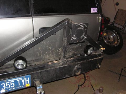 2000 Chevrolet Tahoe - Aftermarket rear bumper and spare tire carrier installed on a silver SUV, with visible wiring and a Michigan license plate.