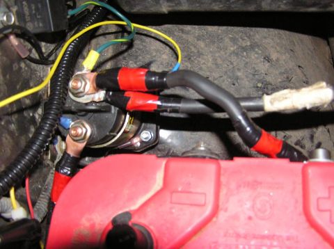 2000 Chevrolet Tahoe - Close-up view of a vehicle's starter solenoid and battery connections, showing wiring and terminals.