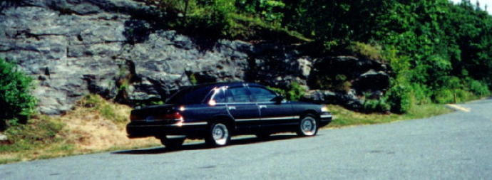 Dark 1997 Ford Crown Victoria sedan parked on a roadside