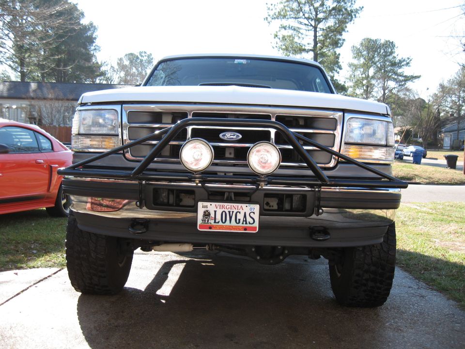 White Ford truck front view, bull bar with lights, Virginia license plate LOVGAS