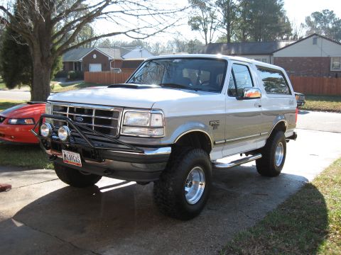 1994 Ford Bronco - This two-tone 1994 Ford Bronco is parked on a concrete driveway in front of a residential house.