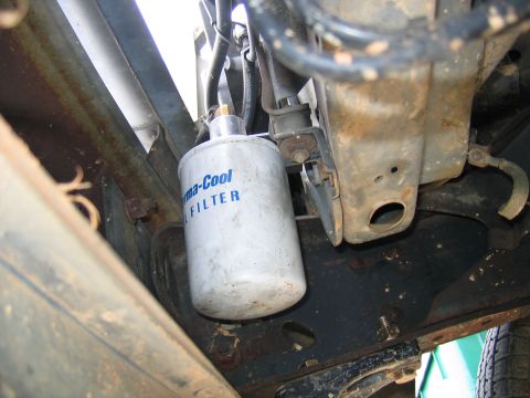 1989 Ford Bronco - A white transmission fluid filter with blue lettering is visible, mounted to the underside of a vehicle.