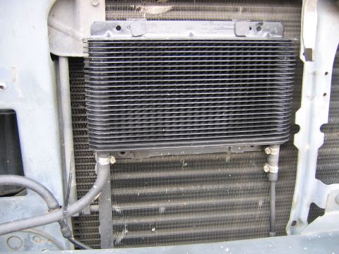 1989 Ford Bronco - Close-up of a transmission cooler and radiator assembly, showing hoses and mounting brackets.