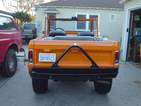 1977 Ford Bronco - Rear view of an orange Ford Bronco with a spare tire carrier and California license plate.
