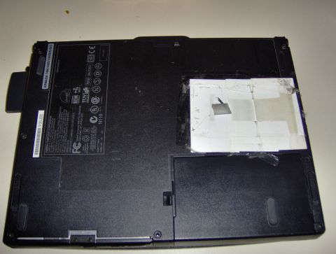 2004 Ford F-150 - The bottom of a laptop computer shows various labels and a section covered with tape.