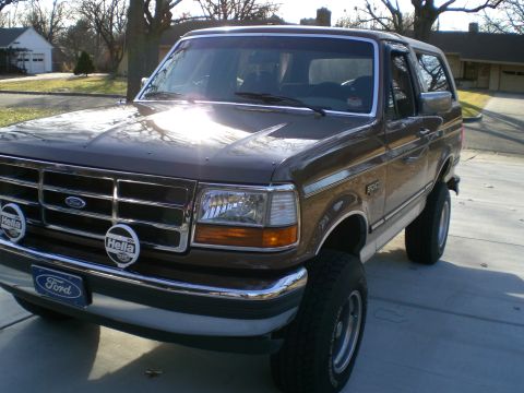 1992 Ford Bronco - Brown 1992 Ford Bronco parked on a driveway, showing front and side profile.