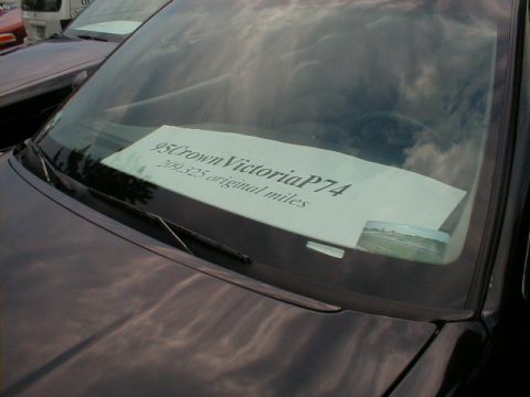 1997 Ford Crown Victoria - A sign on the windshield indicates the vehicle is a 1995 Crown Victoria with over 200,000 miles.