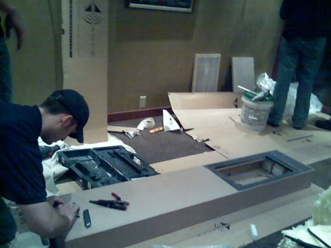 2006 Ford E350 - A group of people are engaged in what appears to be a construction or installation project indoors.