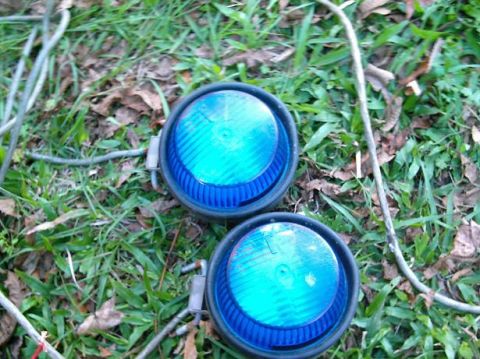 1986 Ford Bronco - Two blue lights with ribbed lenses and black housings are visible on the ground.