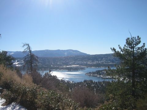 2000 Jeep Cherokee - A wide view of a lake surrounded by snow-dusted trees and mountains on a bright, sunny day.
