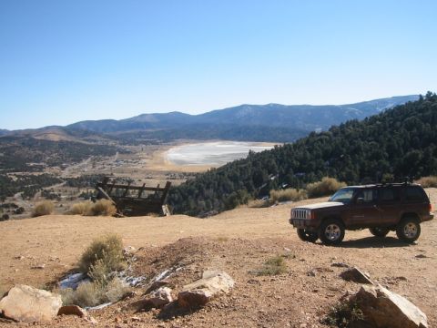 2000 Jeep Cherokee - A maroon 2000 Jeep Cherokee is parked on a dusty, rocky hillside with a valley and mountains in the background.