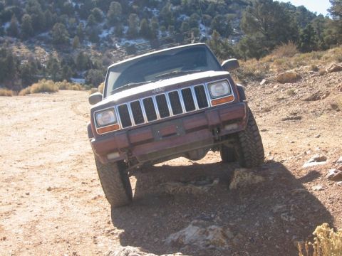 2000 Jeep Cherokee - A red 2000 Jeep Cherokee navigates a challenging rocky trail.
