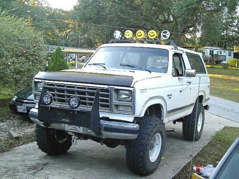 1986 Ford Bronco - This lifted SUV features a custom bull bar and additional lighting on the roof rack.