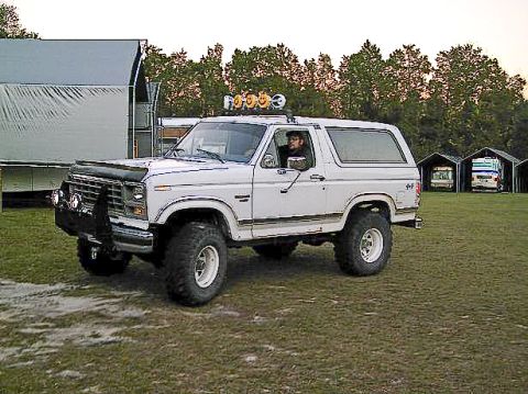 1986 Ford Bronco - This lifted 1986 Ford Bronco features auxiliary lights on its roof and a prominent front brush guard.