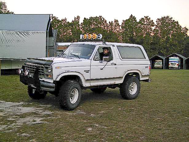 White 1986 Ford Bronco with roof lights and lifted suspension
