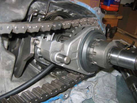 1992 Ford Bronco - Close-up of a disassembled transfer case showing the internal drive chain, sprockets, planetary gear, and the rear output shaft with a spli…