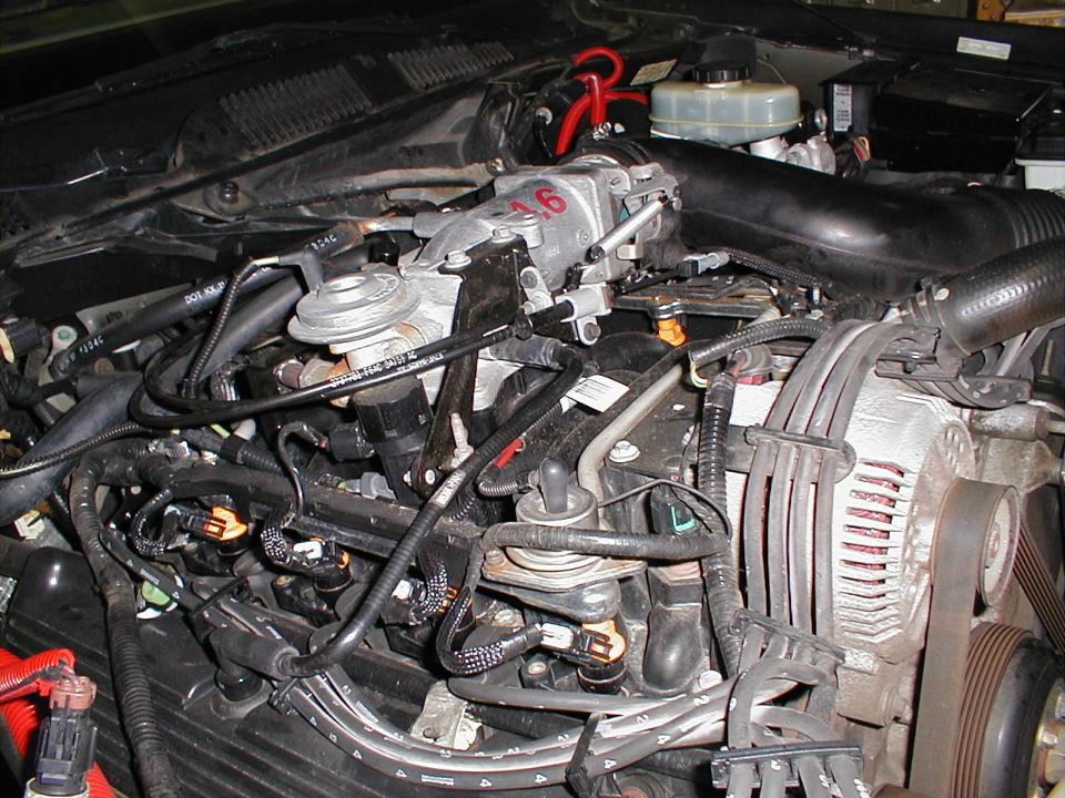 Engine bay showing intake manifold, fuel injectors, and alternator