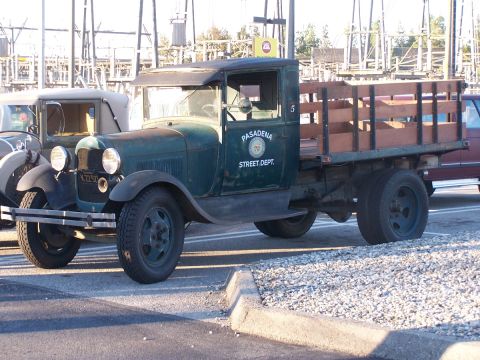 1990 Ford Bronco - A vintage green flatbed truck, marked "PASADENA STREET DEPT.", is parked next to another vehicle.