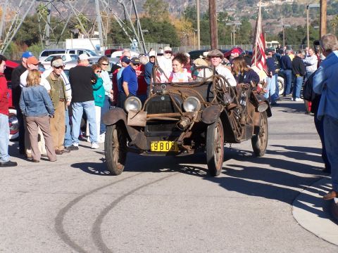 1990 Ford Bronco - An old-fashioned car with a group of people gathered around it.