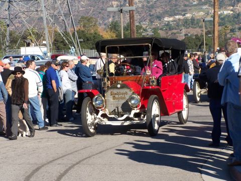 1990 Ford Bronco - Antique Stoddard Dayton touring car on display with onlookers present.