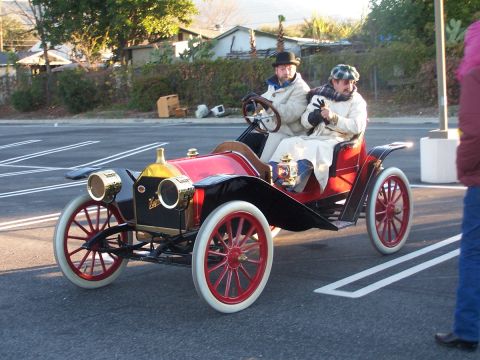 1990 Ford Bronco - Two men in vintage attire ride in an early 20th-century automobile.