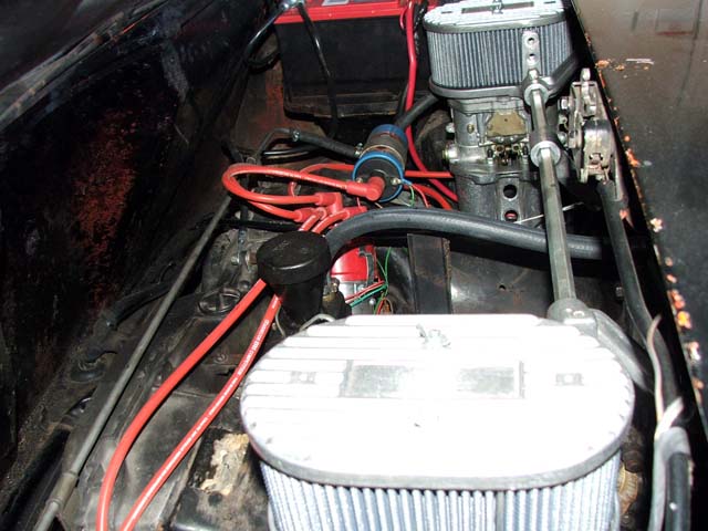 Engine bay with carburetor, chrome air filter, red plug wires and cone filter