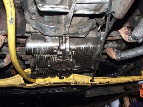 1974 Porsche 914 - Undercarriage view shows the engine and exhaust system, including a prominent yellow hose and ribbed oil pan.
