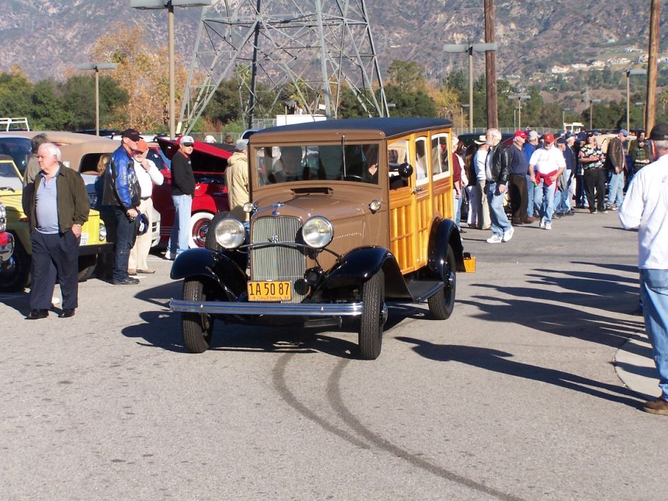 Brown woodie station wagon with black fenders and a yellow license plate