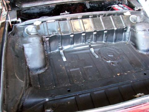 1974 Porsche 914 - The interior of a car's trunk area, with a red battery visible in the background.
