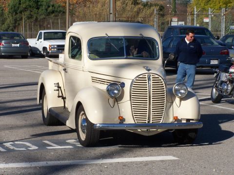 1990 Ford Bronco - A cream-colored vintage truck is parked in a lot with other vehicles.