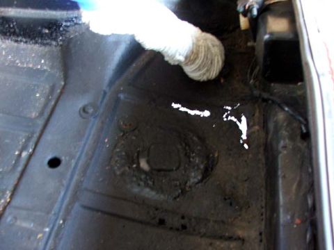 1974 Porsche 914 - Close-up view of a vehicle's interior floor pan, showing some white paint splatters and a white tube-like object.