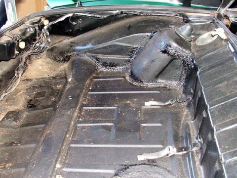 1974 Porsche 914 - Underside view of a car's floor pan, showing undercoating and exposed wiring.