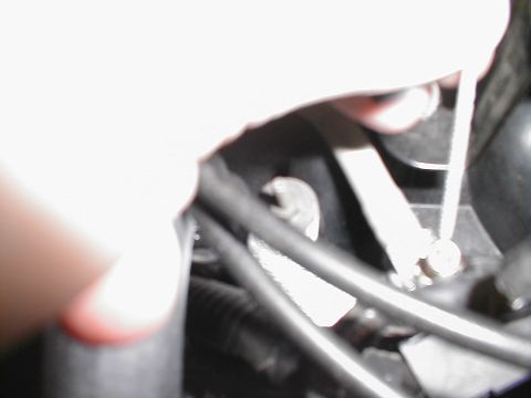 1997 Ford Crown Victoria - Hand working in the engine bay, obscured by bright light and focus.