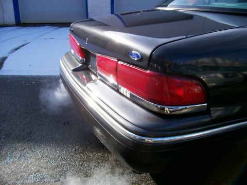 2001 Ford Crown Victoria - A 2001 Ford Crown Victoria seen from the rear, emitting exhaust smoke on a cold day.