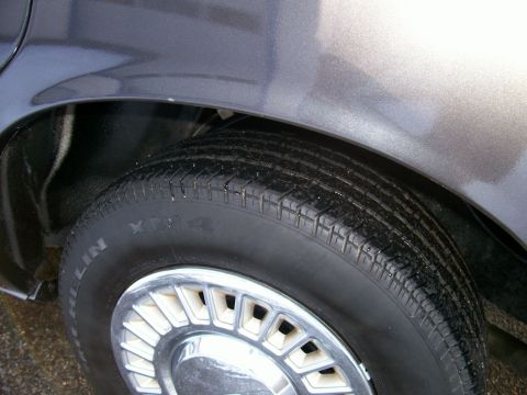 2001 Ford Crown Victoria - Rear wheel well detail of a car, a Michelin tire and a chrome hubcap.