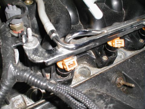 1997 Ford Crown Victoria - Close-up view of engine components, including fuel injectors and a wiring harness, likely during maintenance or modification.