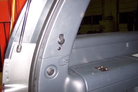2002 Chevrolet Suburban - Close-up of the interior trim panel showing a power outlet and a mounting bracket.