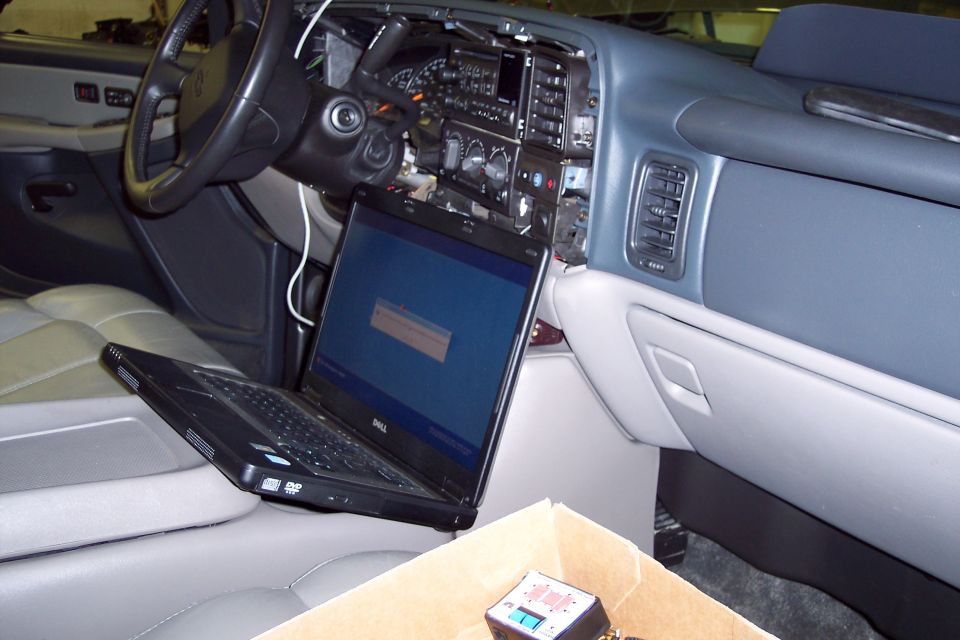 Dashboard of a 2002 Chevrolet Suburban with a laptop open on the center console