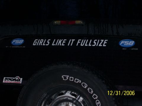 1993 Ford Bronco - Rear view of a black SUV, a spare tire and a humorous decal.