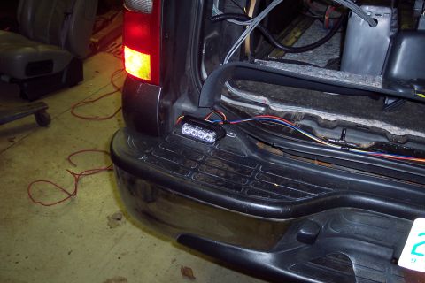 2002 Chevrolet Suburban - Wiring is being installed for an aftermarket light bar on the rear bumper of a vehicle.